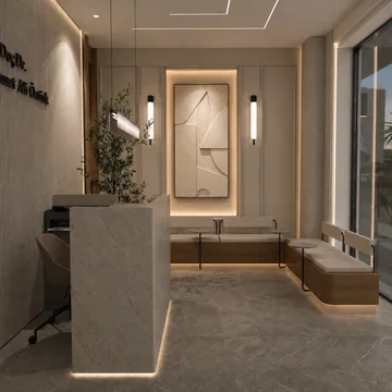 Taş bankolu ve sıcak aydınlatmalı klinik karşılama alanı.